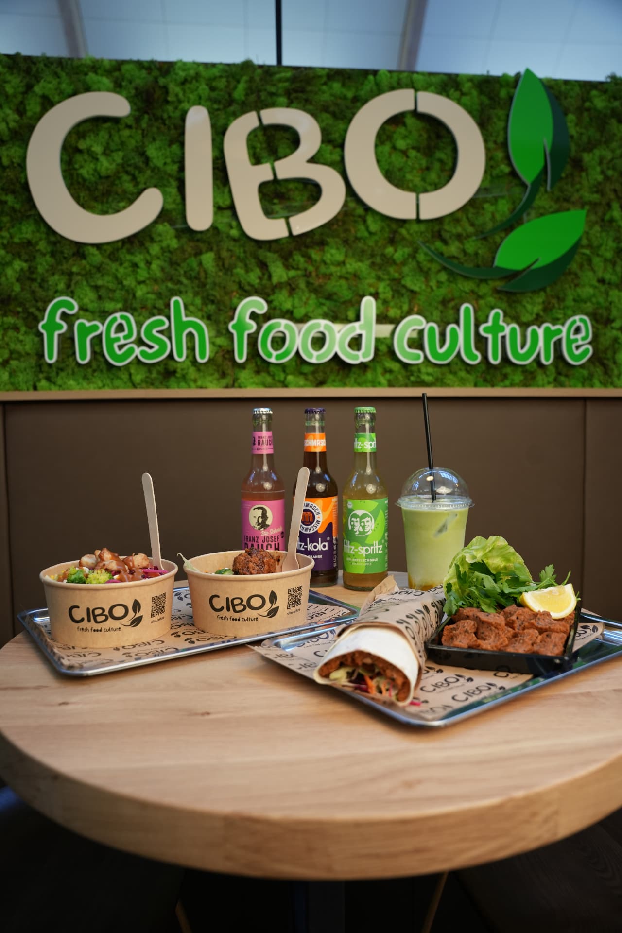 CIBO Bowls, Çiğköfte Wrap, Getränke und Matcha vor der CIBO Mooswand